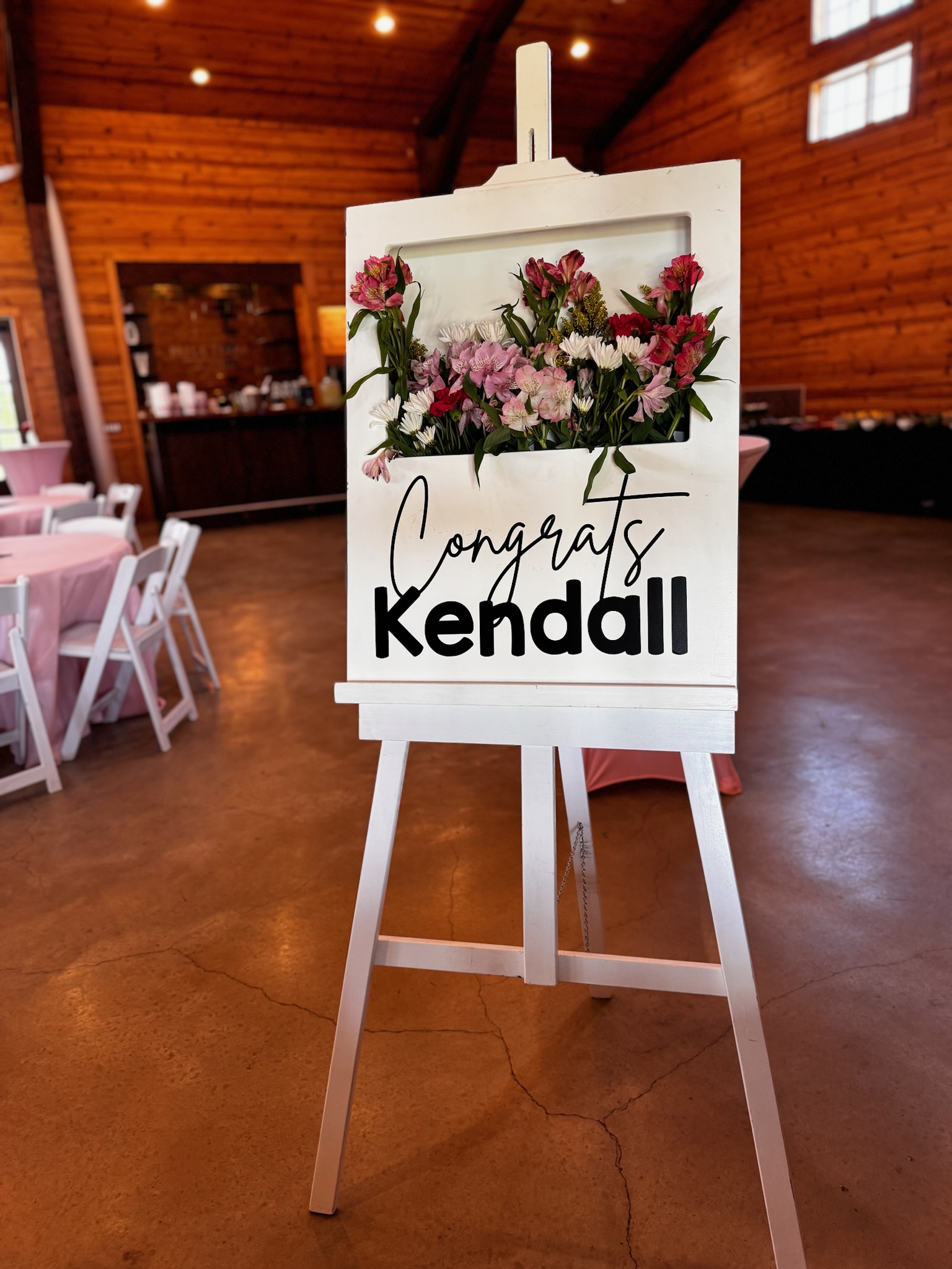 Customized "Congrats, Kendall" sign with live flowers coming out of the sign.