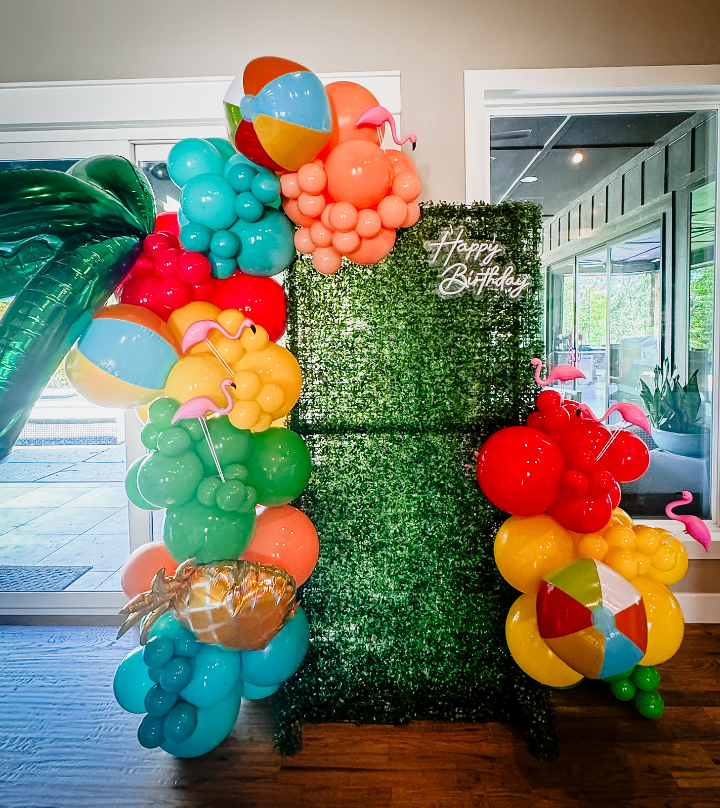 Green picture backdrop with beach ball balloon arch