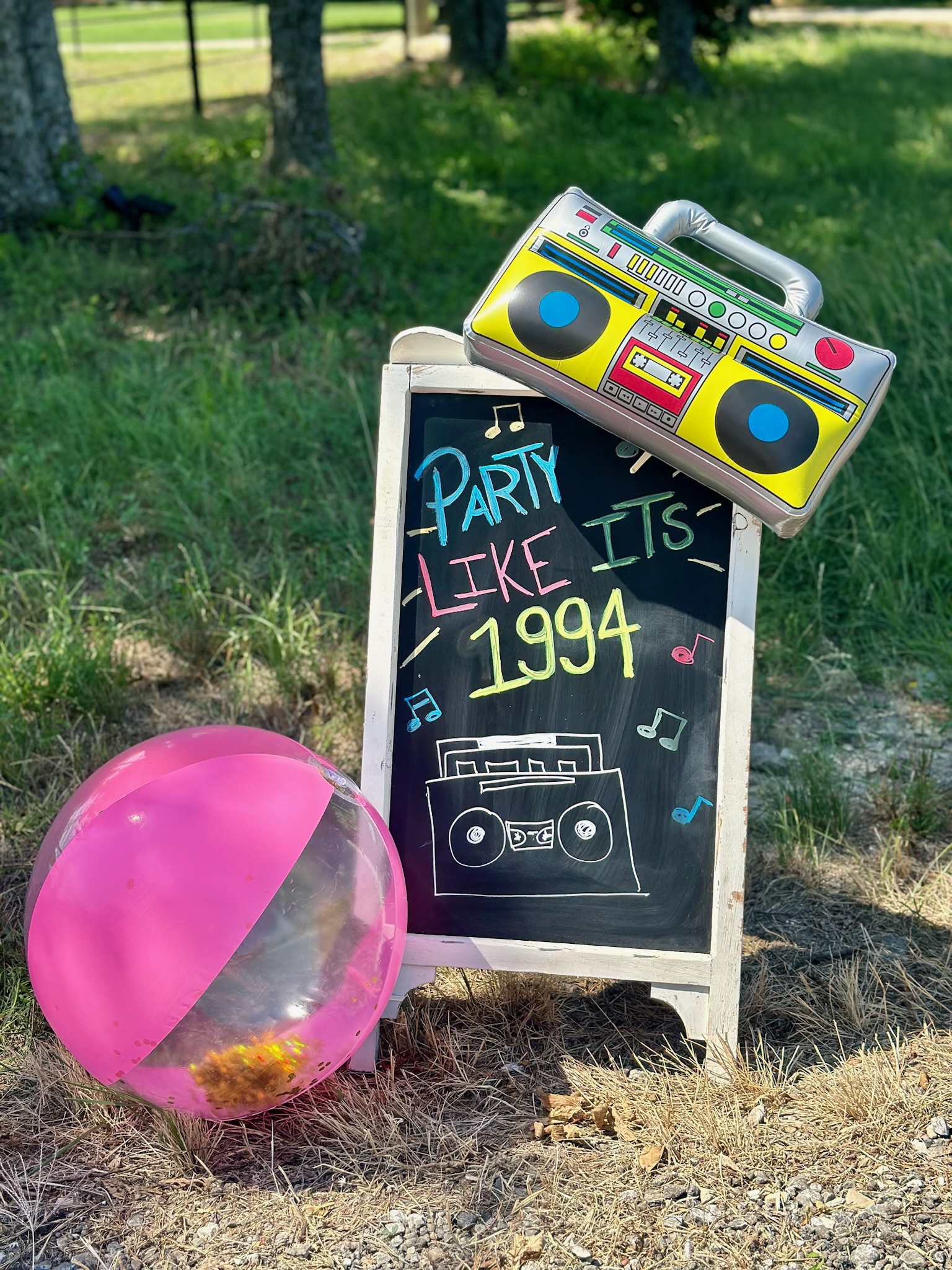 Chalk board with neon writing saying "Party like its 1994" with retro floaties