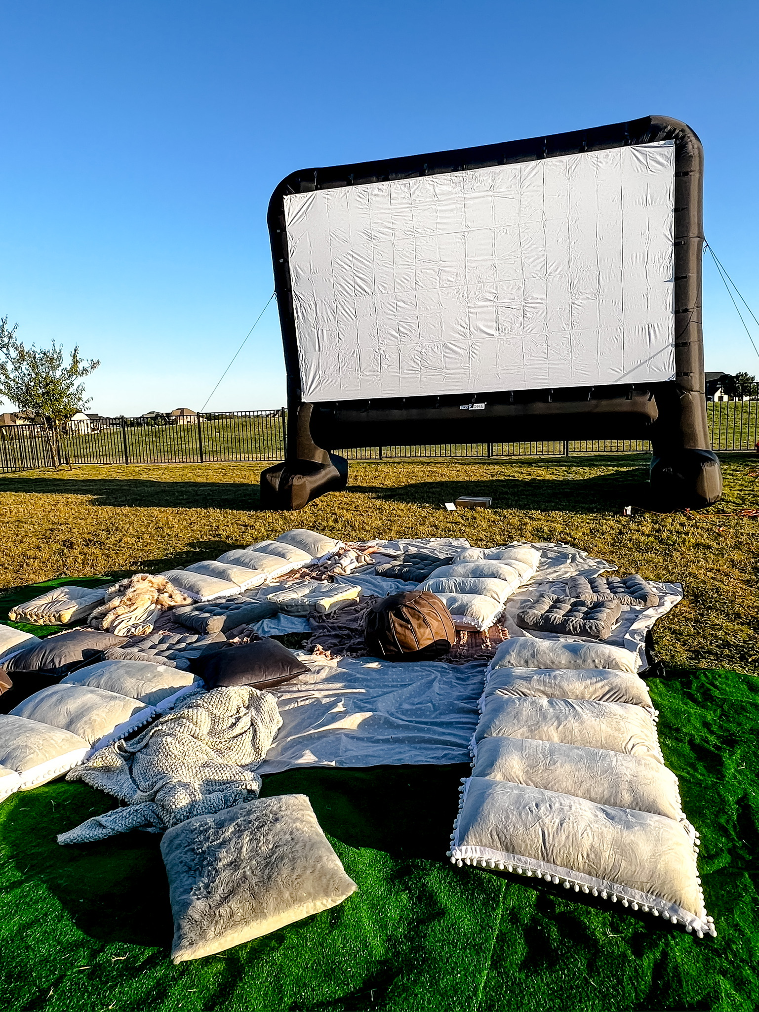 inflatable mega movie projector screen, outdoor movie theater, outdoor home movie set up, floor pillows, outdoor blankets