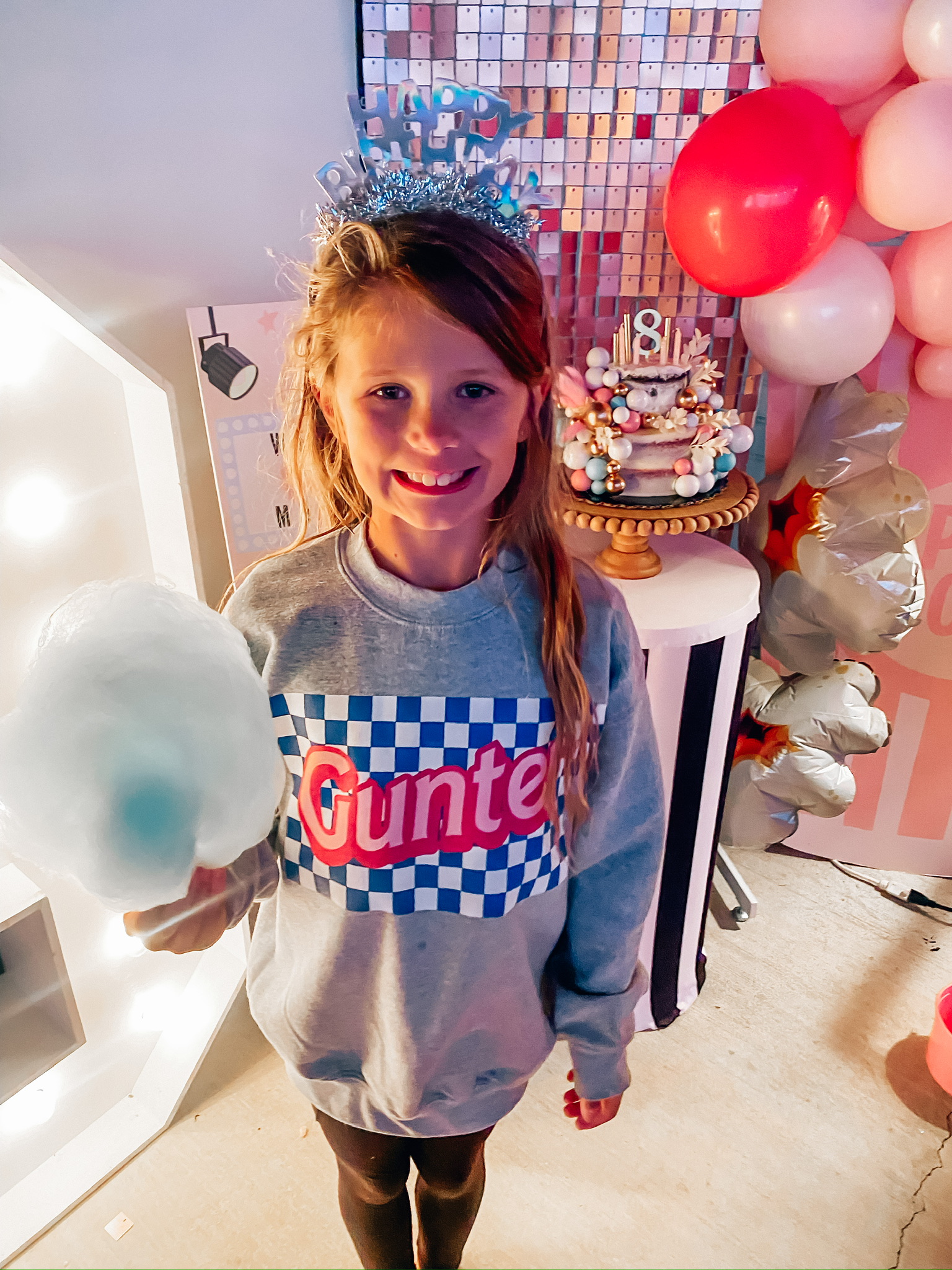 Brynley's Movie Night birthday party, holding blue cotton candy, wearing birthday corwn