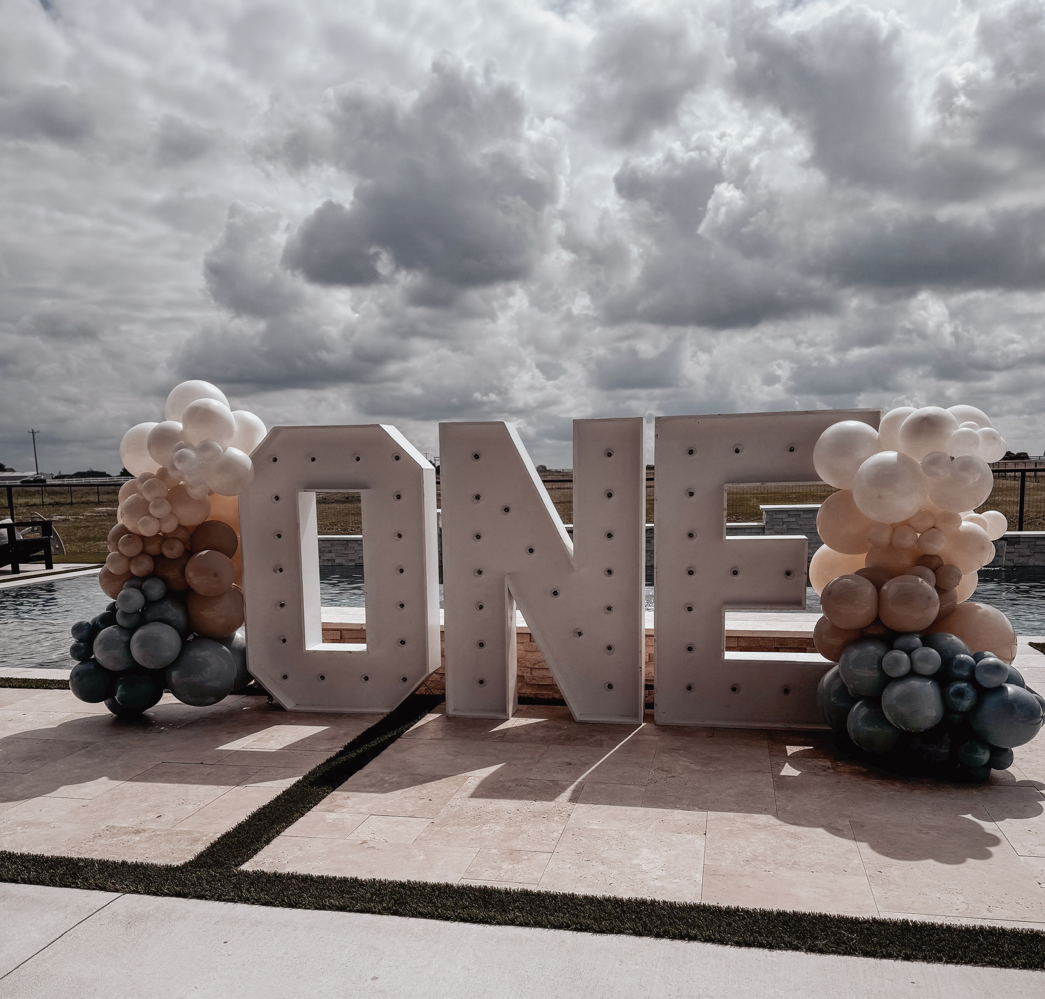 Giant light up letters spelling "one" with balloons