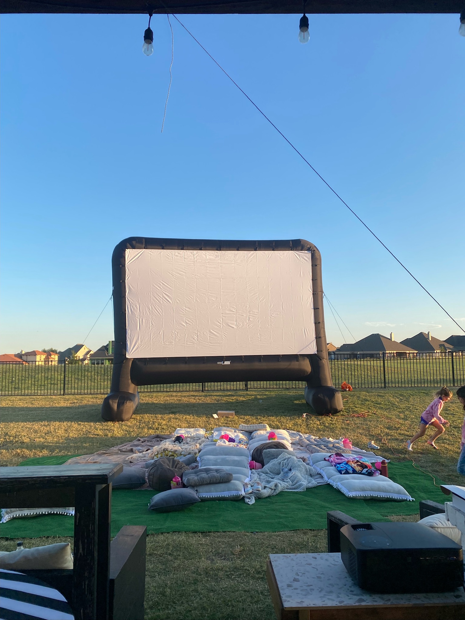 inflatable mega movie projector screen, outdoor movie theater, outdoor home movie set up, floor pillows, outdoor blankets