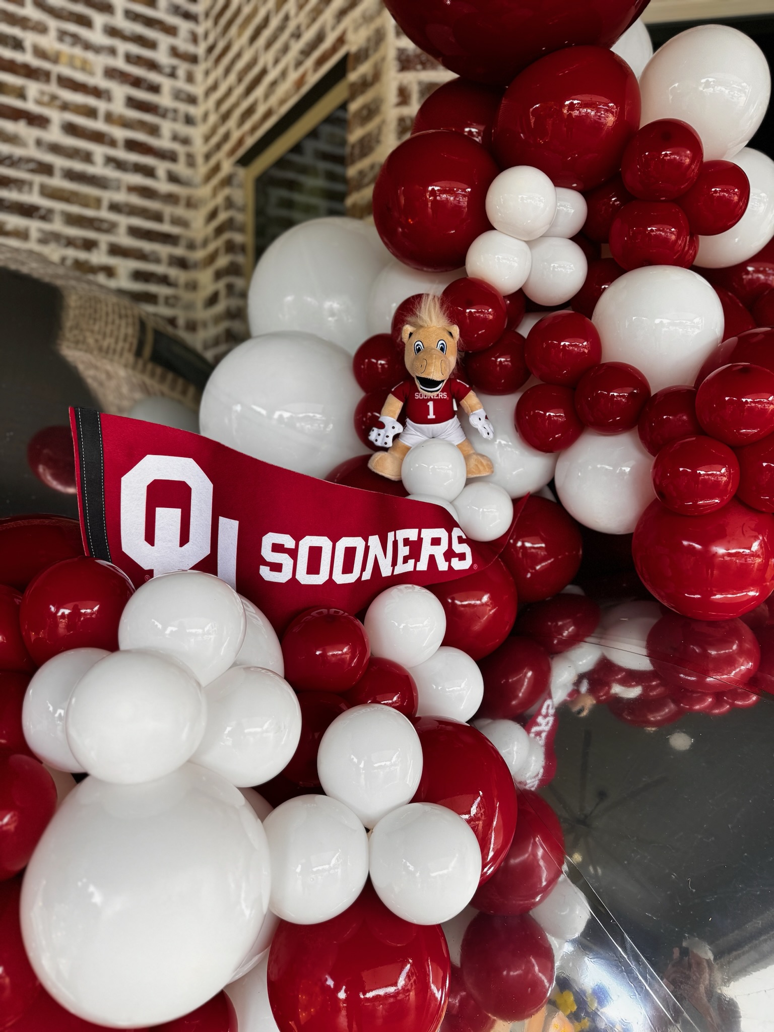 Caps Off, Party On! | Throwing The Ultimate Graduation Party: graduation parties, class of 2025, OU party, bow balloons, pink balloons, photo backdrop, party backdrop, parties, red balloons, white balloons, OU sooners